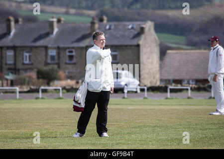 Cricket umpire signalling to the scorers during a village cricket game in England Stock Photo
