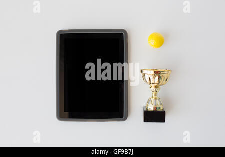 close up of golf ball, cup and tablet pc Stock Photo