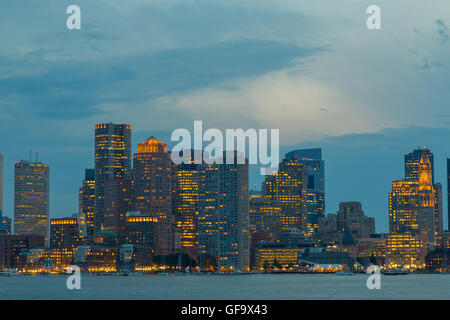 A photograph of the Boston Skyline, as seen from Piers Park in East Boston in the early evening. Stock Photo