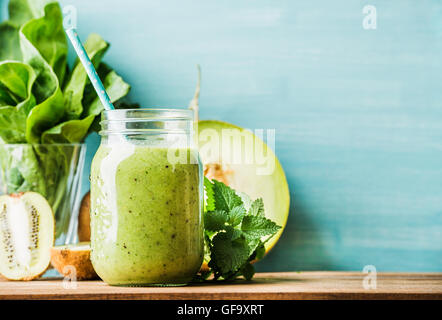 Freshly blended green fruit smoothie in glass jar with straw Stock Photo