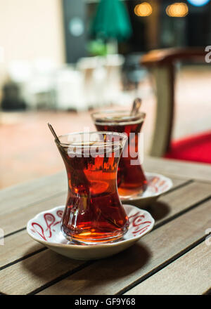 Turkish tea in traditional tulip glasses on table of street cafe Stock Photo