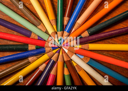 crayons group forming concentric circles on wooden background Stock Photo