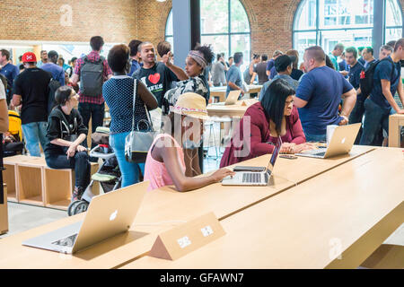 Apple enthusiasts descend on Williamsburg, Brooklyn in New York for the grand opening of Apple's first store in Brooklyn on Saturday, July 30, 2016. The tech company's new store features exposed brick, giant arch windows and at one story with a brick facade blends in with the neighborhood. Apple gave away commemorative tee-shirts to those attending the grand opening. (© Richard B. Levine) Stock Photo