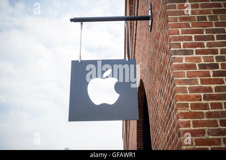 Apple logo sign in Williamsburg, Brooklyn in New York outside of Apple's first store in Brooklyn on Saturday, July 30, 2016. The tech company's new store features exposed brick, giant arch windows and at one story with a brick facade blends in with the neighborhood. Apple gave away commemorative tee-shirts to those attending the grand opening. (© Richard B. Levine) Stock Photo