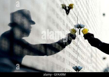 Beijing, China's Hebei Province. 28th July, 2016. A man mourns for relatives killed in the 1976 Tangshan earthquake in front of a memorial wall in Tangshan, north China's Hebei Province, July 28, 2016. © Wu Xiaoling/Xinhua/Alamy Live News Stock Photo