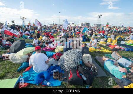 Brzegi, Poland. 30th July, 2016. Pilgrims participating in the World Youth Day 2016 wait for the evening vigil with Pope Francis at the Campus Misericordiae in Brzegi, Poland, 30 July 2016. The World Youth Day 2016 is held in Krakow and nearby Brzegi from 26 to 31 July. Foto: Armin Weigel/dpa/Alamy Live News Stock Photo