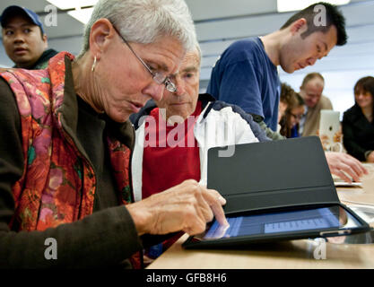 An older woman tries out an Apple iPad at an Apple Store, April 2010. Stock Photo