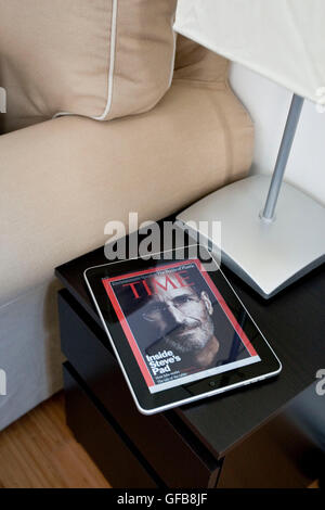 Apple iPad in an apartment coffee table displaying the Time Magazine application with Steve Jobs on the cover, 2010. Stock Photo