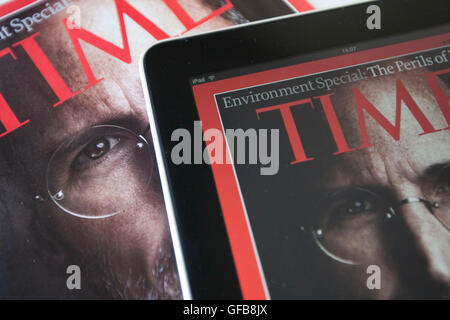 Apple iPad displaying the Time Magazine application on a print version of the magazine with Steve Jobs on the cover, 2010. Stock Photo