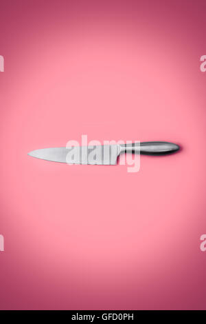 Stainless steel kitchen knife isolated over pink background, Stock Photo