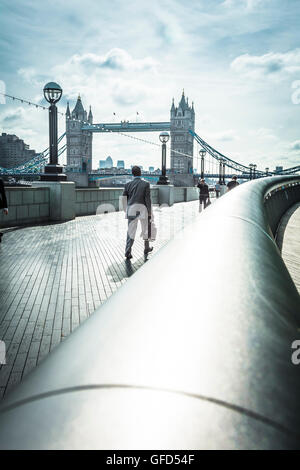 Early morning commuters walking along The Queen's Walk in SE London on the way to work. Stock Photo