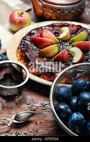 Apple pie with apples and plums in rustic style Stock Photo