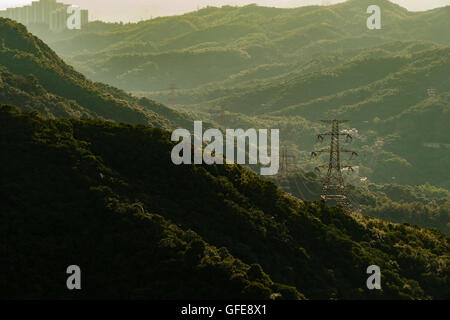 High voltage transmission towers With mountains behind,sunset time Stock Photo