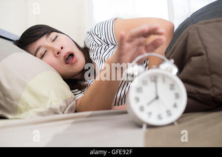 Young woman getting stressed about waking up too early, shallow depth of field, focus on foreground Stock Photo
