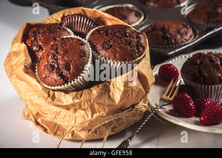 Chocolate muffins with red juicy raspberries