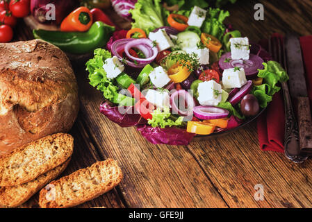 Crisp spring salad with feta cheese, full of vitamins and colors. Greec Salad on vintage table Stock Photo