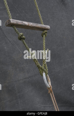 Guy rope fixing of an old canvas army field tent - as a metaphor for the concept of tied down, fixed, held fast, restrained. Stock Photo