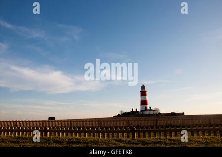 Happisburgh Lighthouse, Great Britain's oldest working lighthouse, in the distance on a summer's evening. Stock Photo