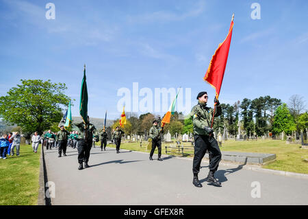 Irish Republican Socialist Party (IRSP) members in paramilitary uniforms carry Irish republican flags during an Easter Rising commemoration remembering Irish National Liberation Army (INLA) volunteers, Belfast, Northern Ireland Stock Photo