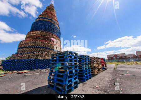 Belfast, Northern Ireland. 9 Jul 2014 - A giant bonfire on Lanark Way dominates the West Belfast skyline. It is estimated to currently be around 140' (40m) in height, with additional pallets to be added. Stock Photo
