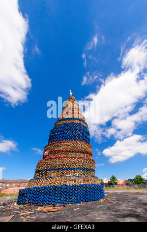 Belfast, Northern Ireland. 9 Jul 2014 - A giant bonfire on Lanark Way dominates the West Belfast skyline. It is estimated to currently be around 140' (40m) in height, with additional pallets to be added. Stock Photo