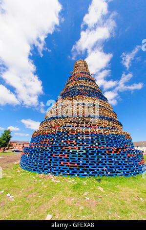 Belfast, Northern Ireland. 9 Jul 2014 - A giant bonfire in the Shankill estate is built to try to compete with a similar one in Lanark Way.  This is currently around 110' (34m) with more pallets to be added. Stock Photo