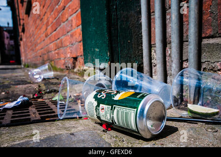 Empty plastic pint glasses and a tin of scrumpy cider littering a city street Stock Photo