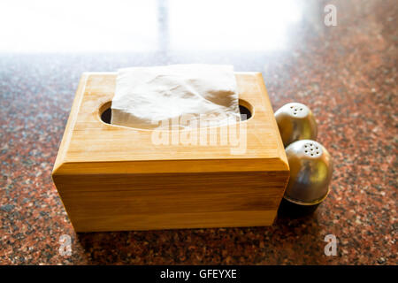 Tissue Paper in the wooden box with Salt & Paper on the Table. Stock Photo