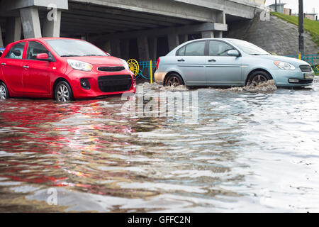 Cars on a flooded city road during the rain Stock Photo