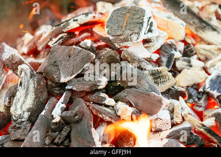 Burning charcoal with orange-colored flame and glow Selective Focus, Focus on parts of the charcoal pieces around the flame Stock Photo
