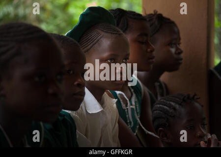 Yongoro, Sierra Leone - June 03, 2013: West Africa, the village of Yongoro in front of Freetown, young girl listen to the lesson Stock Photo