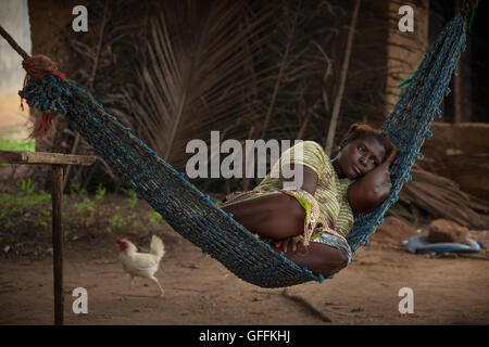 Yongoro, Sierra Leone - June 03, 2013: West Africa, the village of Yongoro in front of Freetown, young woman resting on a hammoc Stock Photo