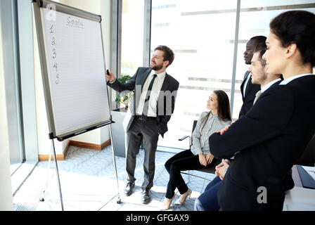 Cheerful businessman discussing new business project with the members of his team Stock Photo