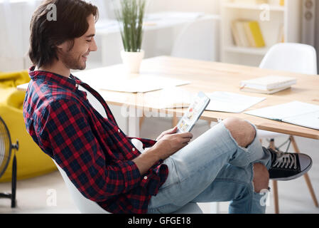 Delighted smiling man using tablet Stock Photo