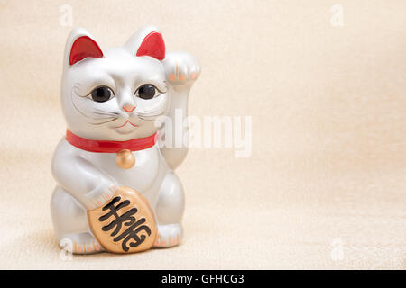 Japanese silver beckoning cat called Manekineko also known as a lucky cat Stock Photo