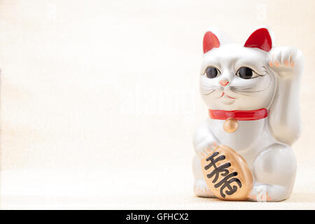 Japanese silver beckoning cat called Manekineko also known as a lucky cat Stock Photo