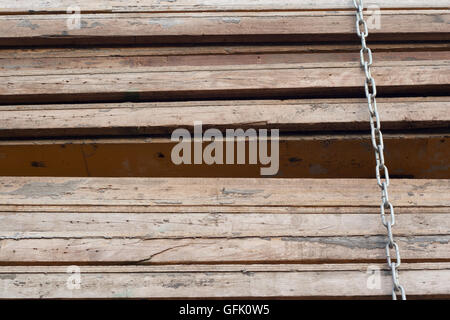 Pile of wood panels tied by a chain in full frame Stock Photo