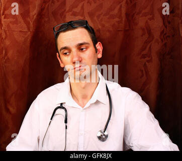 Looking young handsome doctor in medical office Stock Photo