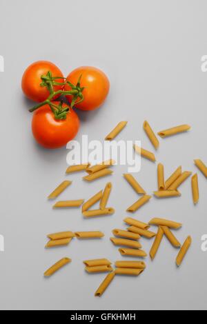 Raw pasta and fresh tomatoes ingredients overhead view Stock Photo
