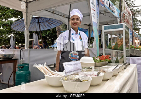 Female chef serving from a street food stall. Thailand S. E. Asia Stock Photo