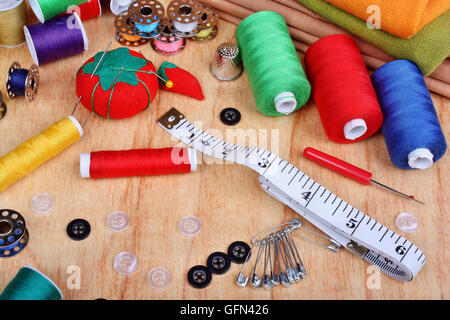 Sewing items: buttons, colorful fabrics, material, measuring tape, bobbins, buttons, cloth, safety pins, needles, pincushion, th Stock Photo