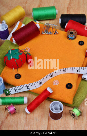 Background vertical with sewing items: buttons, colorful fabrics, material, measuring tape, bobbins, buttons, cloth, safety pins Stock Photo