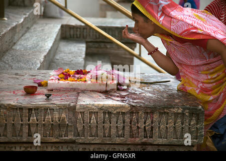 A Hindu woman marks her forhead with a Tilaka or tika in Hindi at the Jagdis Temple in Udaipur, Rajistan, India. Stock Photo