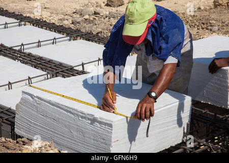 Worker Taking measures of an Iron framework and polyurethane  to build a foundation for a building Stock Photo