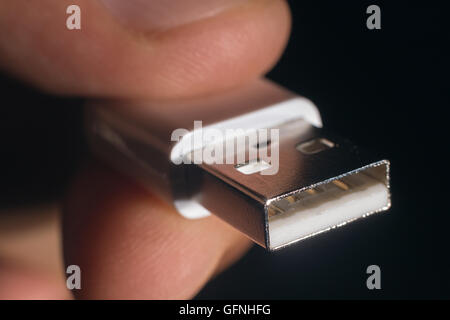 Hand holding white USB cable. Man's hand holds a USB Connector. Closeup man hand holding USB cable. Stock Photo