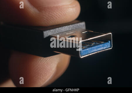 Hand holding black USB cable. Man's hand holds a USB Connector. Closeup man hand holding USB cable. Stock Photo