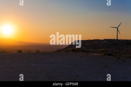 Electric wind turbines farm with sunset light on arid landscape, Spain Stock Photo