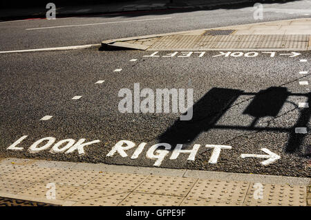Warning signs painted on the road at a pedestrian crossing to look for traffic. Stock Photo