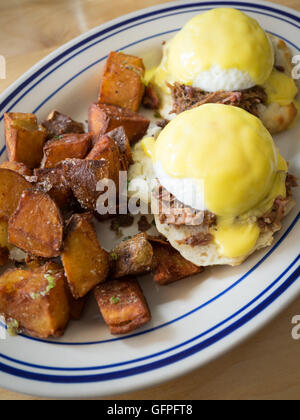 Beef brisket Eggs Benedict and fried potatoes for breakfast. MEAT Restaurant, Edmonton, Alberta, Canada Stock Photo