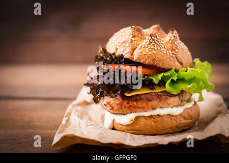 Big sandwich - hamburger with juicy turkey burger, cheese, tomato and tartar sauce Stock Photo